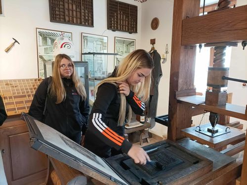 A tanulók megtekintenek egy régi nyomdagépet